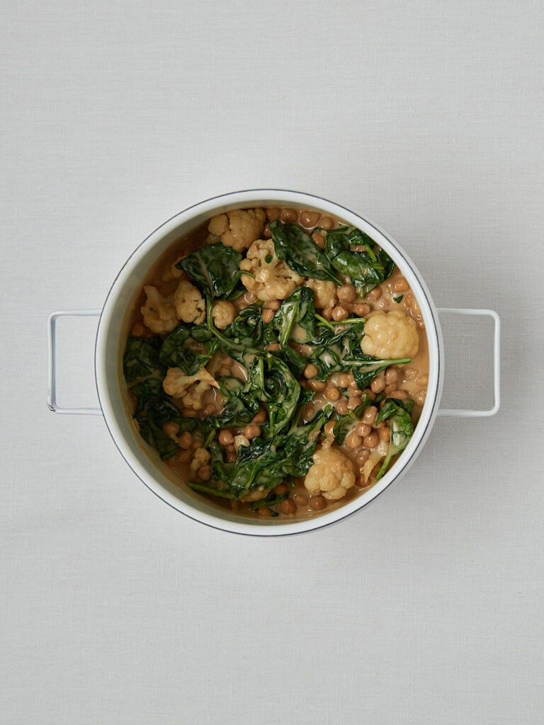 Spinat und Blumenkohl in weißer Schüssel – Zubereitungsschritt Overhead