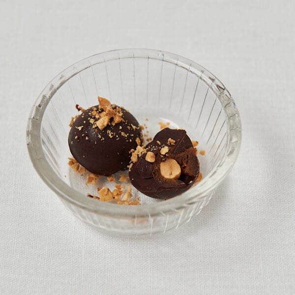 Zwei Toffifee Pralinen mit Haselnüssen in Glasschüssel – seitliche Aufnahme